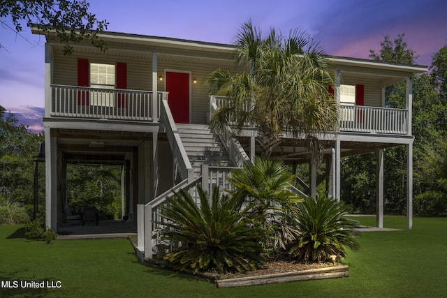 raised beach house with a patio area and a lawn