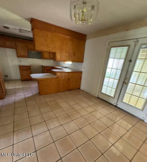 5 Union Church Rd, Tylertown, MS 39667 - kitchen featuring brown cabinets, light tile patterned floors, and a chandelier