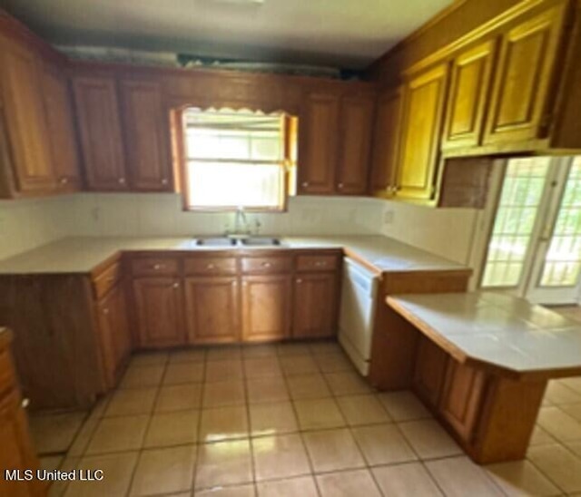5 Union Church Rd, Tylertown, MS 39667 - kitchen with a sink, light countertops, white dishwasher, light tile patterned flooring, and brown cabinets