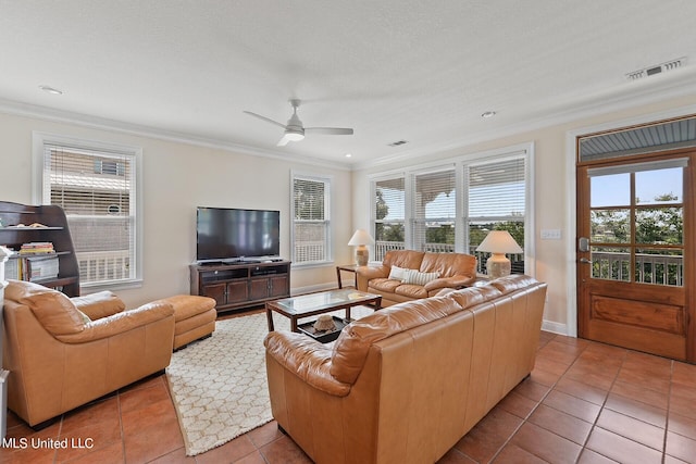 living room with ceiling fan, a textured ceiling, tile patterned floors, and crown molding