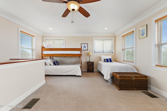 carpeted bedroom with ceiling fan, ornamental molding, and multiple windows