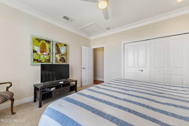 carpeted bedroom featuring ceiling fan, a closet, and crown molding