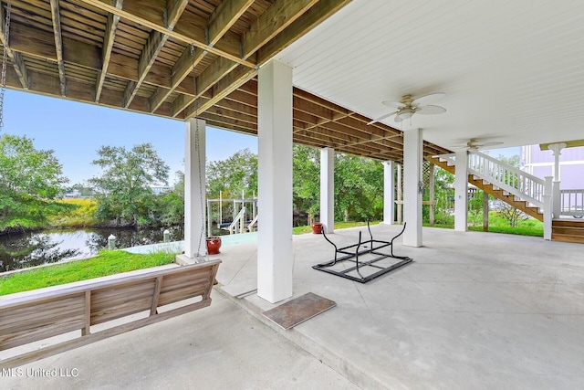 view of patio with ceiling fan and a water view