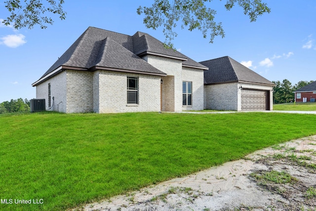 view of front facade featuring a garage, central AC unit, and a front lawn