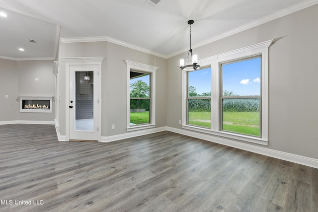 unfurnished dining area featuring wood-type flooring, a chandelier, and crown molding