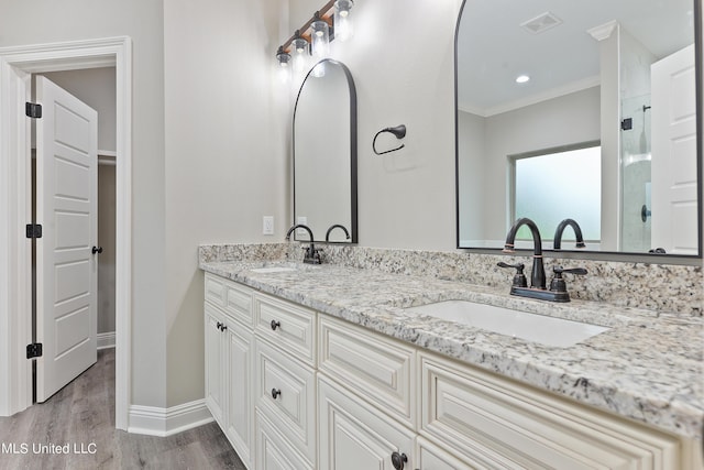 bathroom featuring vanity, a shower with door, crown molding, and hardwood / wood-style floors