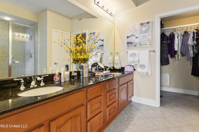 2668 Beach Blvd Unit 304, Biloxi, MS 39531 - full bath featuring tile patterned flooring, a shower stall, double vanity, a spacious closet, and baseboards