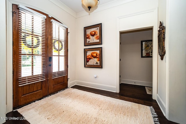 foyer featuring dark hardwood / wood-style flooring, ornamental molding, and french doors