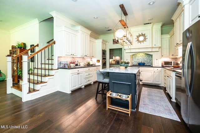 kitchen with a center island, decorative backsplash, a kitchen bar, and decorative light fixtures