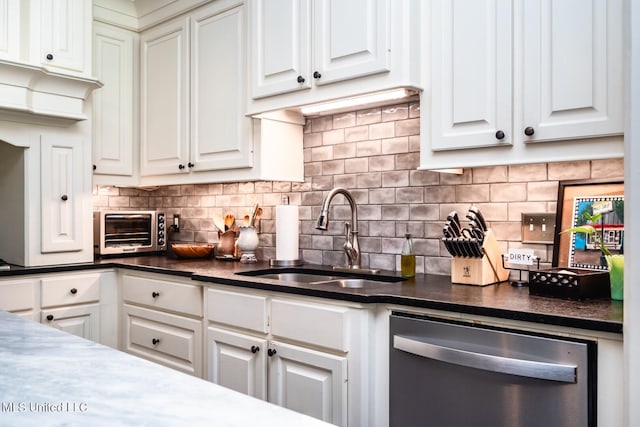 kitchen featuring tasteful backsplash, sink, stainless steel dishwasher, and white cabinets