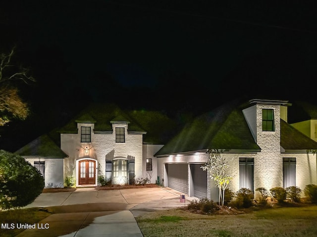 french provincial home featuring french doors and a garage