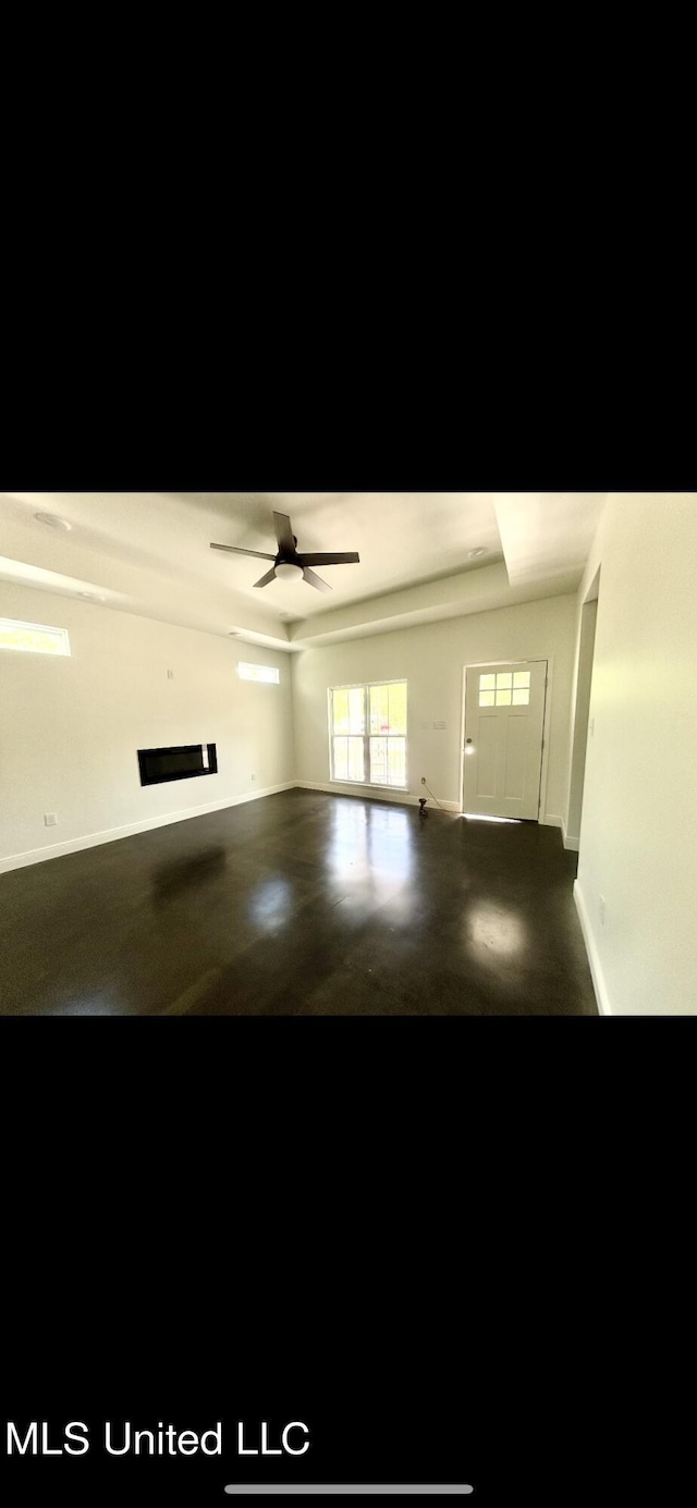 interior space with baseboards and ceiling fan