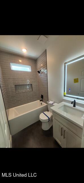 bathroom with toilet, shower / tub combination, finished concrete floors, and vanity