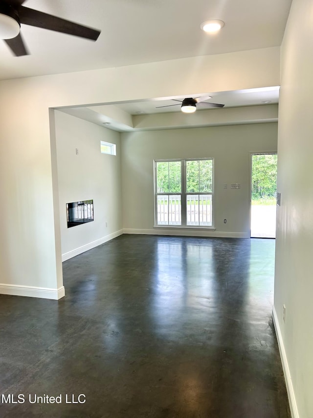 unfurnished room featuring ceiling fan and a healthy amount of sunlight