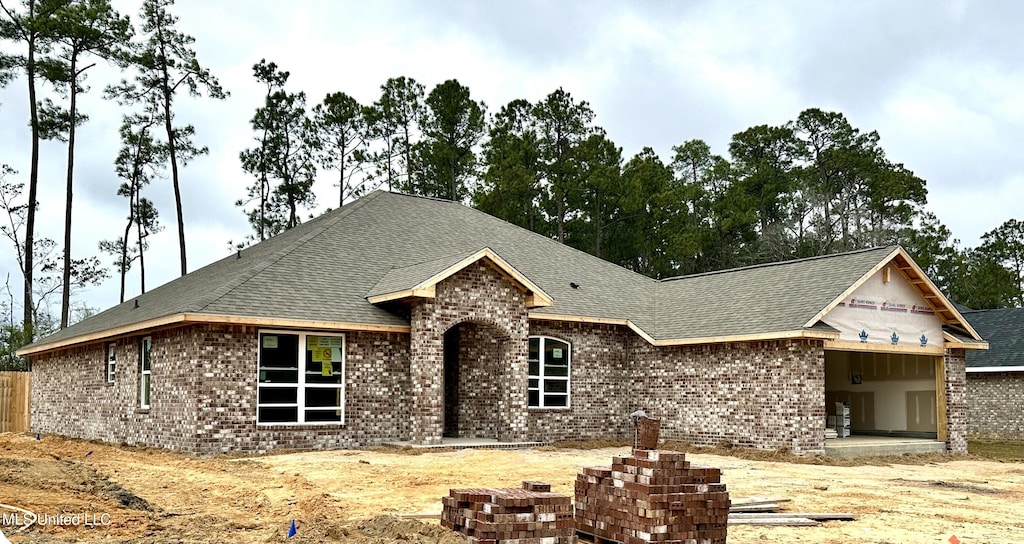 view of front of house with brick siding and a shingled roof