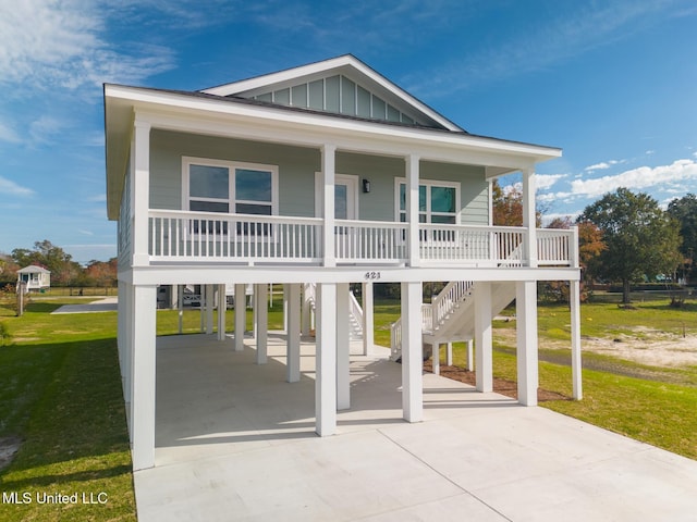 view of front of home featuring covered porch, a front lawn, and a carport