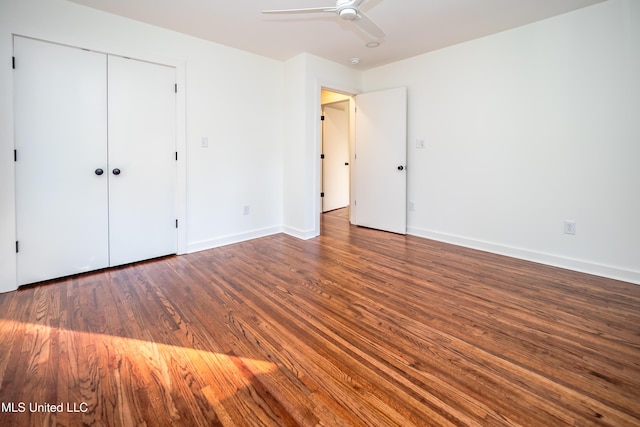 unfurnished bedroom featuring ceiling fan, dark wood-type flooring, and a closet