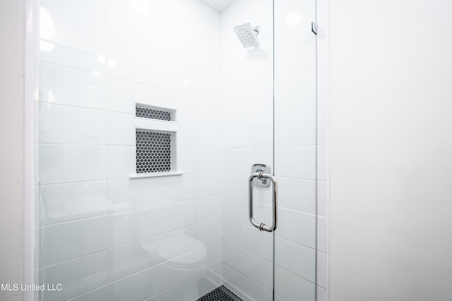 bathroom featuring a shower with shower door