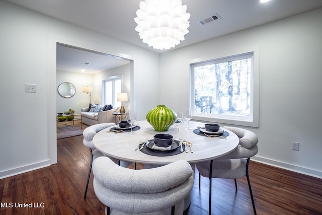 dining space featuring a notable chandelier and dark hardwood / wood-style flooring