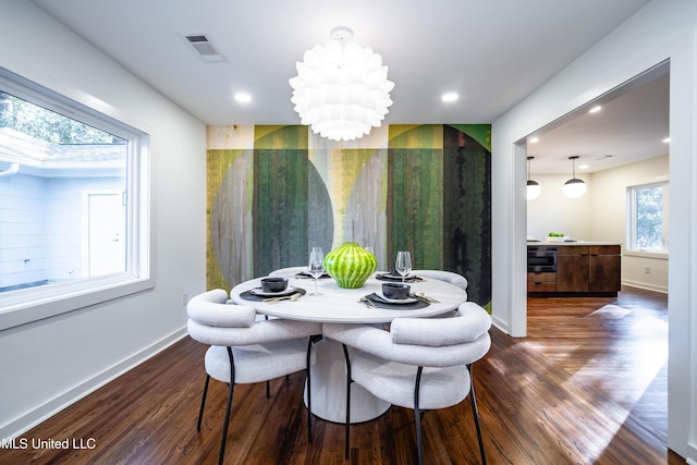 dining area with an inviting chandelier and dark wood-type flooring