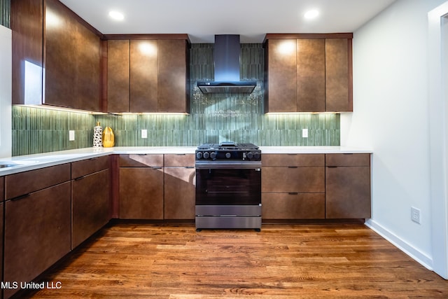 kitchen featuring backsplash, gas stove, wall chimney range hood, and dark wood-type flooring