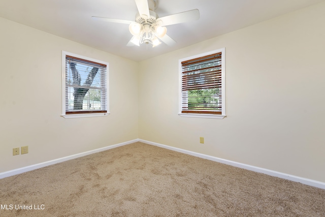 carpeted empty room featuring plenty of natural light and ceiling fan