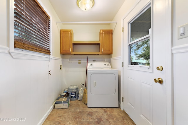 clothes washing area featuring cabinets and washer / clothes dryer