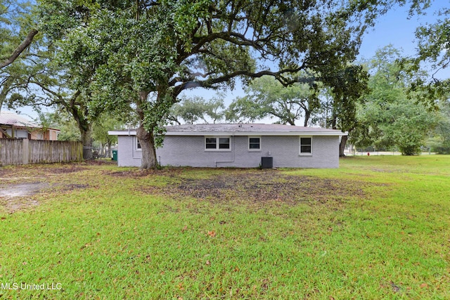 back of property with cooling unit and a yard