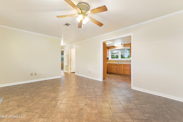 empty room featuring ceiling fan, sink, and ornamental molding