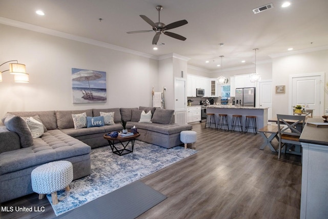 living room featuring ornamental molding, ceiling fan with notable chandelier, and dark hardwood / wood-style flooring