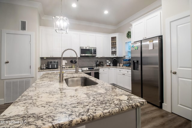 kitchen with ornamental molding, white cabinets, decorative light fixtures, and stainless steel appliances