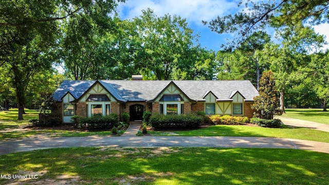 tudor-style house with a front yard