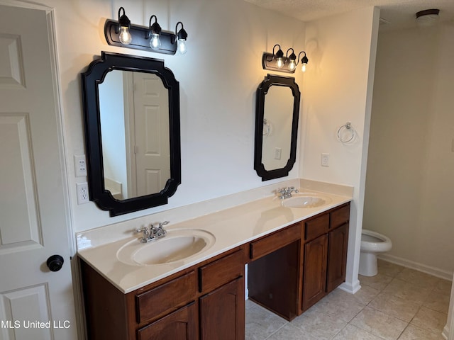 bathroom featuring vanity, tile patterned floors, and toilet