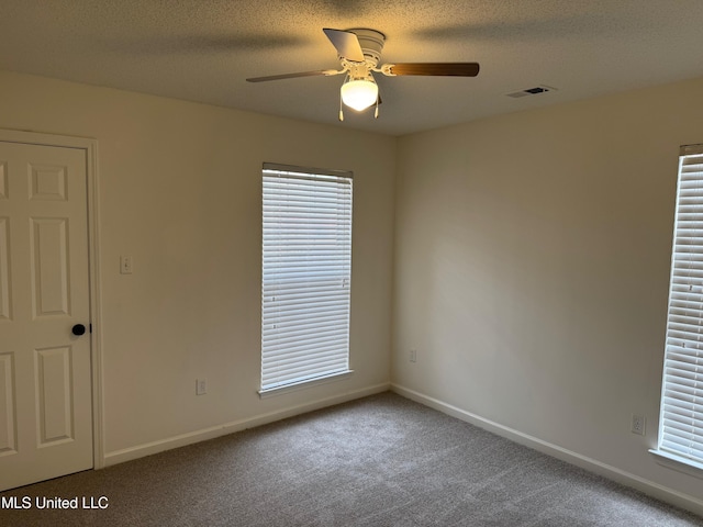 spare room featuring ceiling fan, carpet flooring, and a textured ceiling