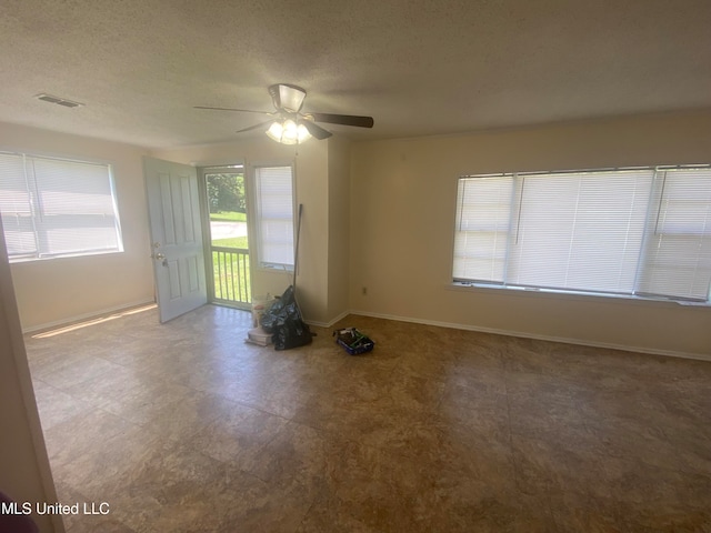 empty room featuring a textured ceiling and ceiling fan