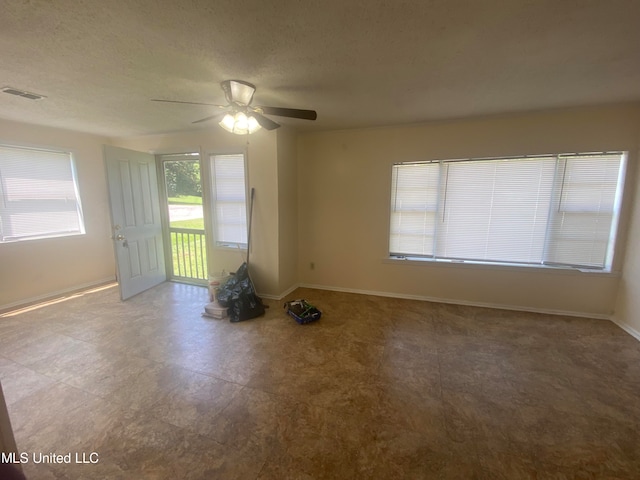 spare room featuring a textured ceiling and ceiling fan