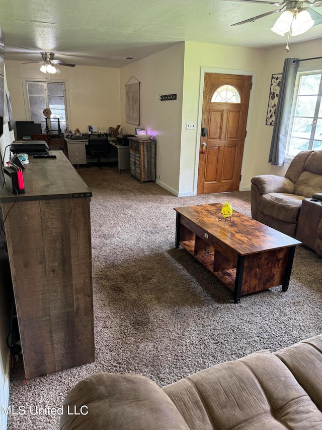 carpeted living room featuring ceiling fan and a textured ceiling