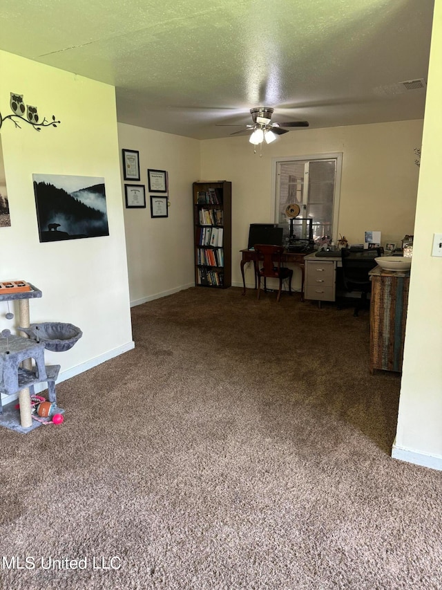 living room featuring ceiling fan, carpet flooring, and a textured ceiling