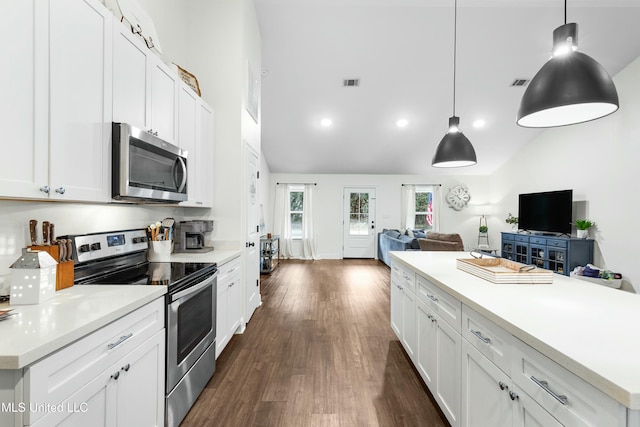 kitchen featuring decorative light fixtures, stainless steel appliances, light countertops, and open floor plan