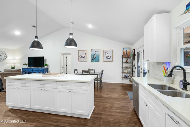 kitchen featuring dark wood-style floors, pendant lighting, light countertops, white cabinetry, and a sink