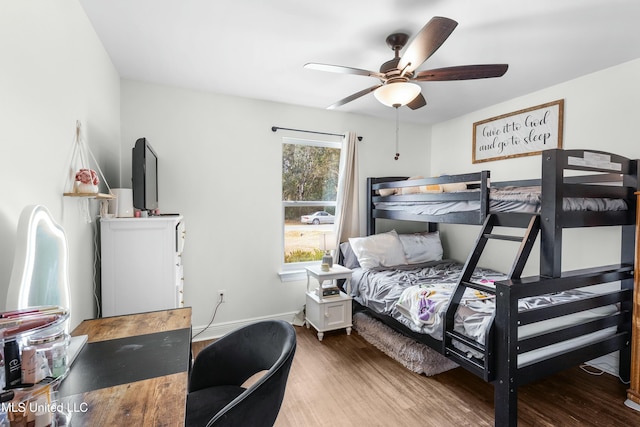 bedroom featuring a ceiling fan, baseboards, and wood finished floors