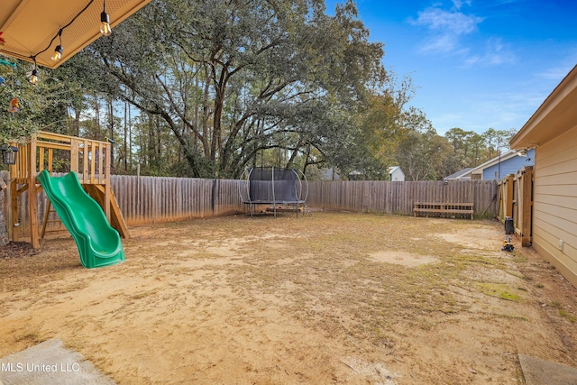 view of yard featuring a fenced backyard, a trampoline, and a playground