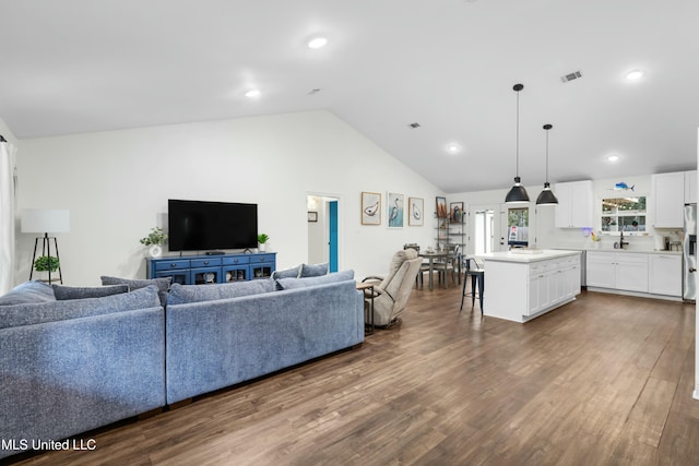 living area with high vaulted ceiling, wood finished floors, visible vents, and recessed lighting