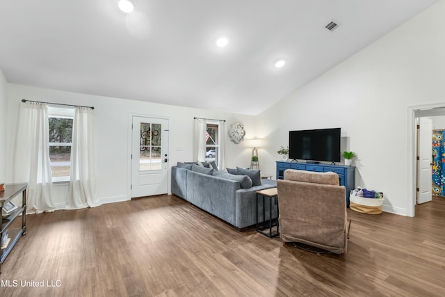 living area featuring recessed lighting, wood finished floors, visible vents, baseboards, and vaulted ceiling