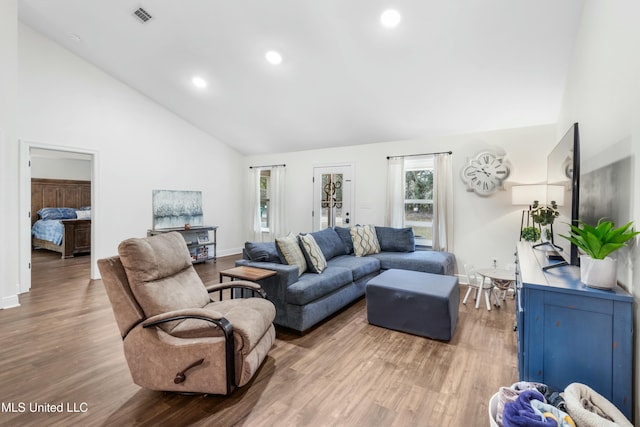 living room with high vaulted ceiling, recessed lighting, visible vents, and wood finished floors