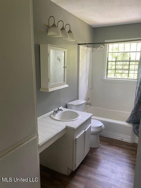 2804 Revere St, Jackson, MS 39212 - full bath featuring toilet, bathtub / shower combination, vanity, and wood finished floors