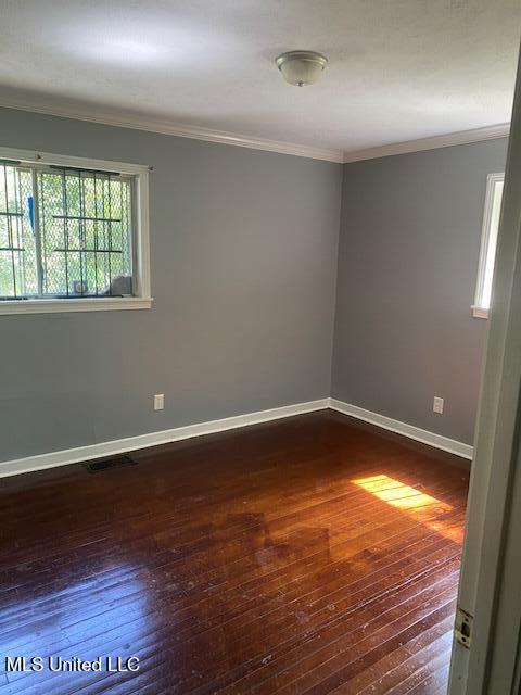 2804 Revere St, Jackson, MS 39212 - unfurnished room featuring dark wood-type flooring, ornamental molding, and baseboards