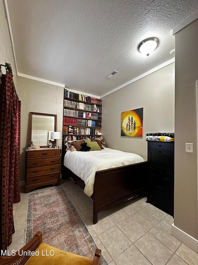 515 Krebs Ave, Pascagoula, MS 39567 - bedroom with crown molding, light tile patterned floors, concrete block wall, and a textured ceiling