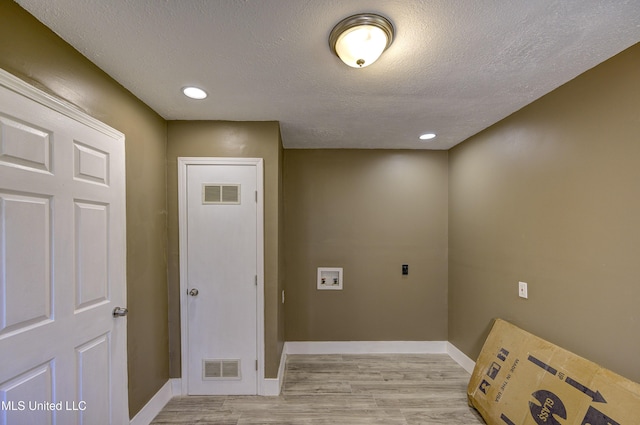 223 Second Ave, Vicksburg, MS 39183 - laundry room featuring washer hookup, hookup for an electric dryer, light wood-type flooring, and a textured ceiling