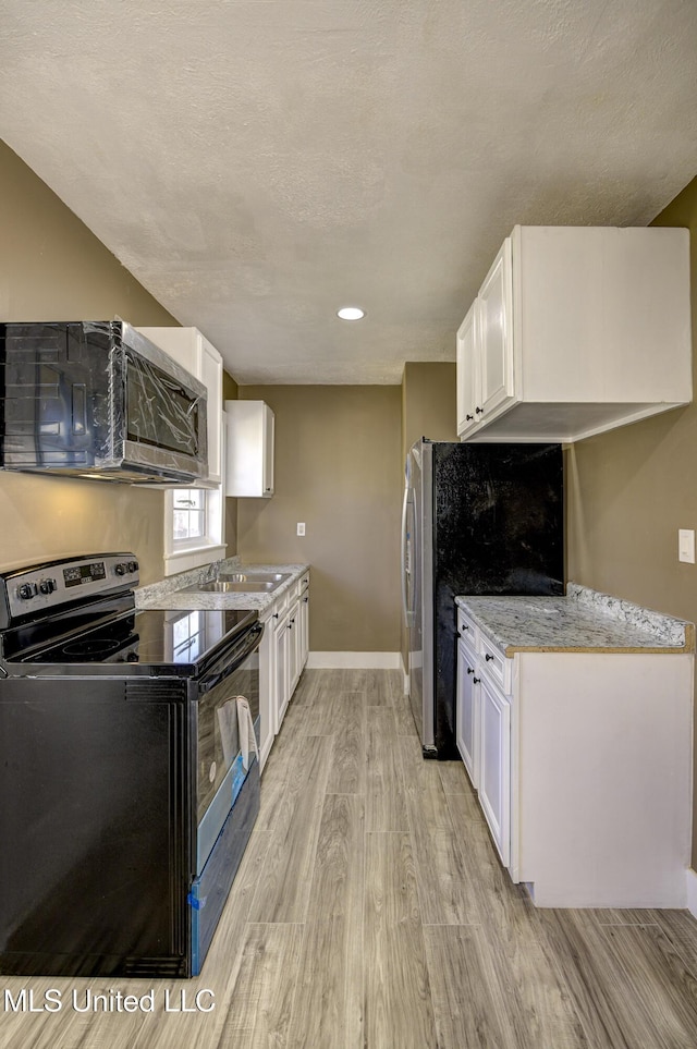 223 Second Ave, Vicksburg, MS 39183 - kitchen featuring white cabinets, light wood-type flooring, and electric range